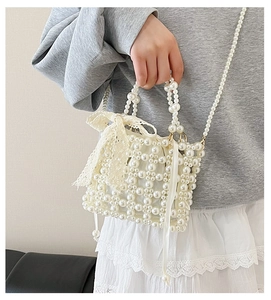 Detailed shot of pearl woven handbag featuring a beige lace bow and drawstring liner