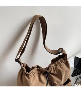 Detailed view of the adjustable long shoulder strap and drawstring closure on canvas bag