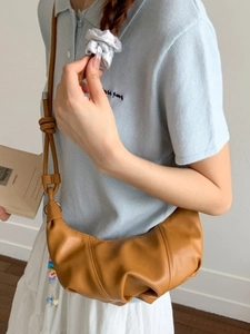 Caramel pleated crescent shoulder bag with knotted strap and colorful charm detail