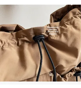 Detail shot of the drawstring closure on a durable brown canvas shoulder bag with toggles