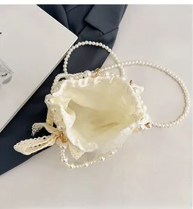 Top view of pearl beaded bucket bag showing satin lining and lace bow detail