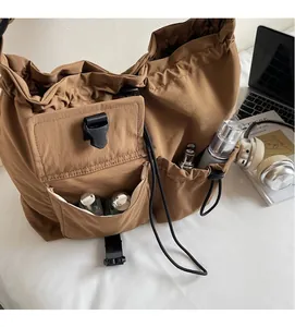 Detail view of brown nylon tote bag with functional pockets and drawstring closure