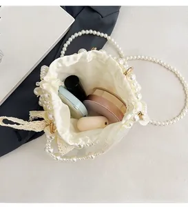 White bucket bag with pearl embellishments showing interior space for cosmetics