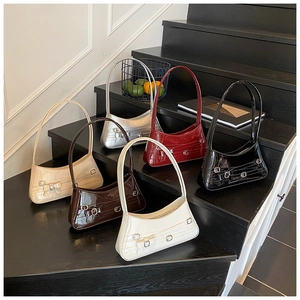 Chic patent leather underarm bags with bow accents in six colors on tiered display
