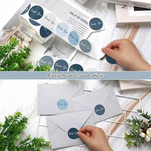 Blue Thank You stickers shown on a grey envelope and in rolls with a marble background