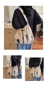 Detail view of large nylon tote bag with drawstring closure and multiple utility pockets
