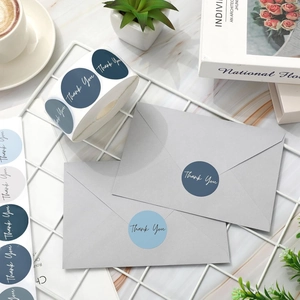 Close-up of blue Thank You stickers for envelopes with professional office background
