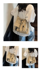 Detail of drawstring closure and buckle pocket on beige canvas crossbody shoulder bag