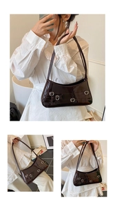 Detail of dark brown patent leather shoulder bag with silver buckles and bow decoration