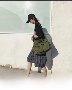 Olive green canvas messenger bag featuring multi-pocket utility design and wide strap