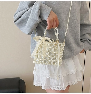 Detail of woven pearl handbag featuring a large lace bow and elegant chain strap