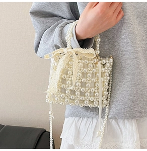 Detailed view of woven pearl handbag featuring delicate lace bow and silk lining