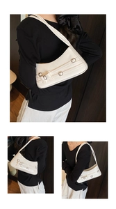 Detail of white glossy patent leather shoulder bag with silver metallic buckle straps