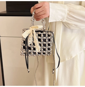 Detail of silver beaded handbag featuring a delicate yellow lace bow and black ribbon