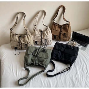 Detail view of large capacity drawstring canvas crossbody bags in five colors