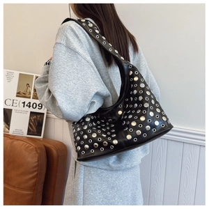Détail du sac seau punk noir avec rivets et œillets en métal argenté sur l'épaule