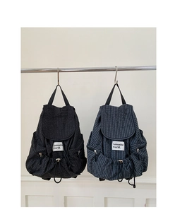 Dettaglio degli zaini in nylon a quadri con chiusura a coulisse ed etichetta del marchio