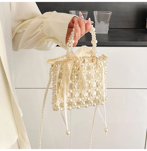 Detailed close-up of pearl woven handbag with lace bow and satin drawstring inner