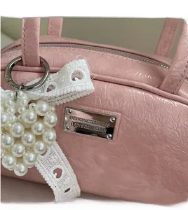 Détail de la texture similicuir rose avec nœud en dentelle et breloque cœur perlé