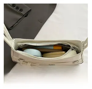 Macro view of white bow shoulder bag interior showing capacity for phone and cosmetics