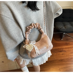 Détails d'un sac à main rose froncé élégant avec pendentif cœur en perle