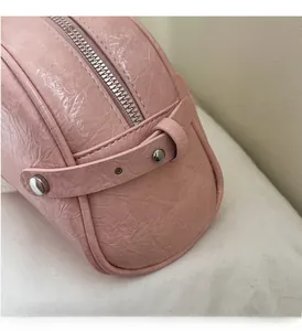 Vue détaillée de la texture du cuir plissé rose pâle avec fermeture éclair en métal argenté