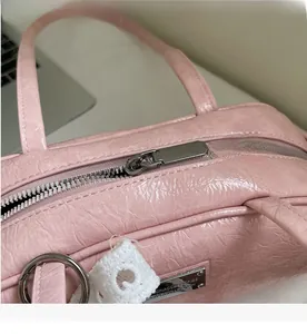 Vue macro de la texture plissée rose avec fermeture éclair argentée et plaque logo de marque