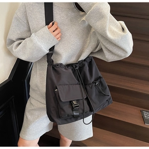 Detail of black nylon messenger bag with adjustable shoulder strap and buckle flap pocket