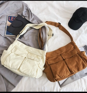 Detail of canvas messenger bag featuring dual front flap pockets and adjustable straps