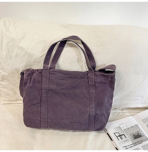 Detail of dark purple canvas tote bag featuring large side pocket and adjustable strap