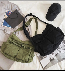 Detail of canvas messenger bag with dual front pockets and adjustable nylon shoulder strap
