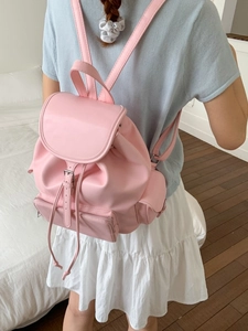Pink vintage PU leather backpack with flap and buckle closure shown on model in indoor setting