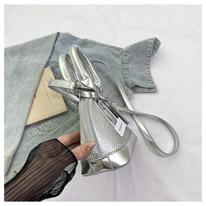 Detail of silver snake-pattern shell bag with metallic trim on white cloth background