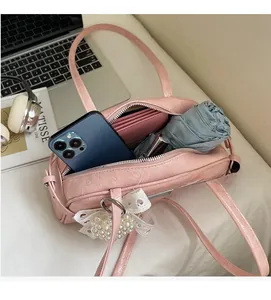 Vue de dessus montrant la capacité interne du sac bowling rose avec dentelle et objets