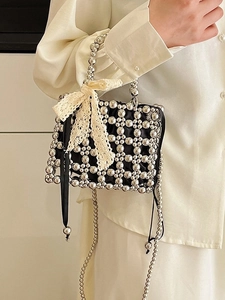 Elegant black beaded handbag with silver grid texture and a delicate lace bow accent