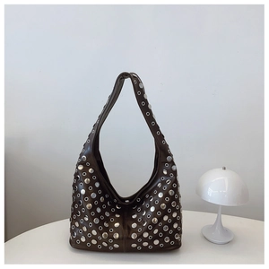 Gros plan du sac seau punk marron avec œillets métalliques et large bandoulière