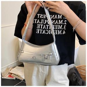 Detail of silver metallic crescent bag with bow accent and sleek shoulder strap