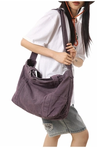 Detail view of large purple canvas tote bag worn by model showing side pockets and wide strap