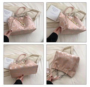 Detail view of pink heart jacquard tote bag featuring pearl chain and metal handles