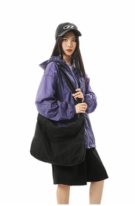 Close-up of black canvas tote bag showing wide straps and reinforced side pockets