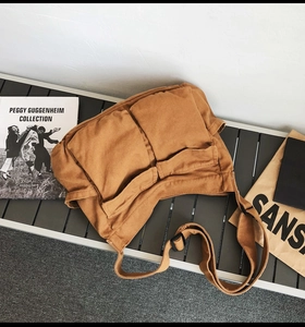 Detail of vintage canvas crossbody bag showing dual front pockets and wide strap