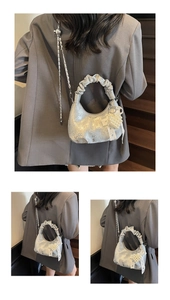 Detail of silver metallic handbag with pearl heart charm and pleated handle detail