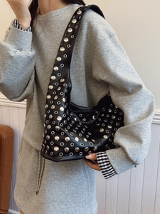 Sac seau punk noir orné de clous argentés porté par un mannequin pour un look urbain