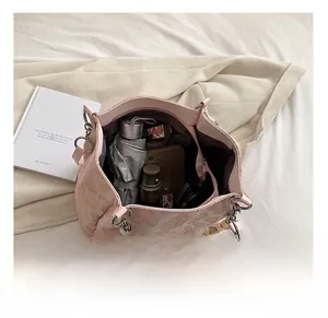 Detail view of pink tote bag interior showing capacity for cosmetics, phone and umbrella