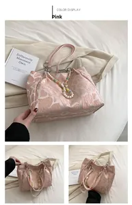 Detail of pink tote bag featuring heart pattern jacquard and pearl decorative chain