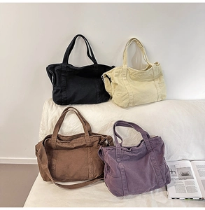Detail view of large canvas tote bags in four colors with side pockets and shoulder straps