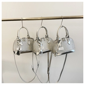 Detailed view of silver glitter shell bags with metallic handles and textured finishes