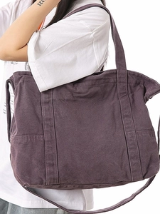 Large dark purple canvas tote bag with wide shoulder straps and side pockets for commuting