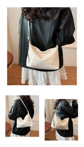 Close-up of creamy white hobo bag showing a silver heart pendant and smooth leather texture