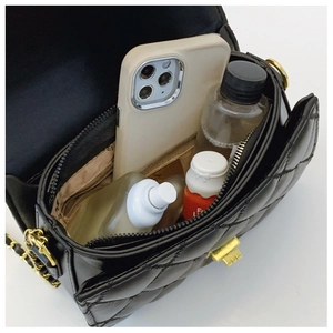 Quilted black PU leather bag interior showing spacious capacity with mobile and cosmetics